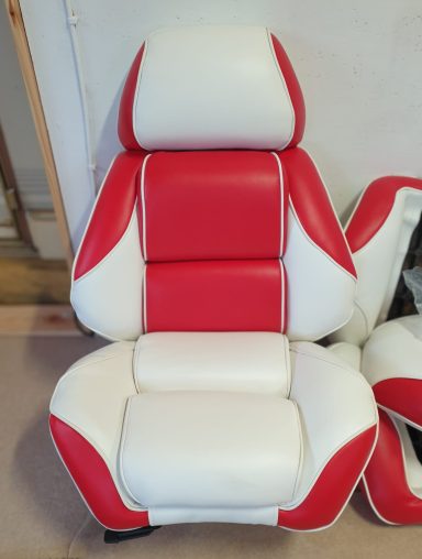Roter und weißer Autositz mit gepolstertem Design.